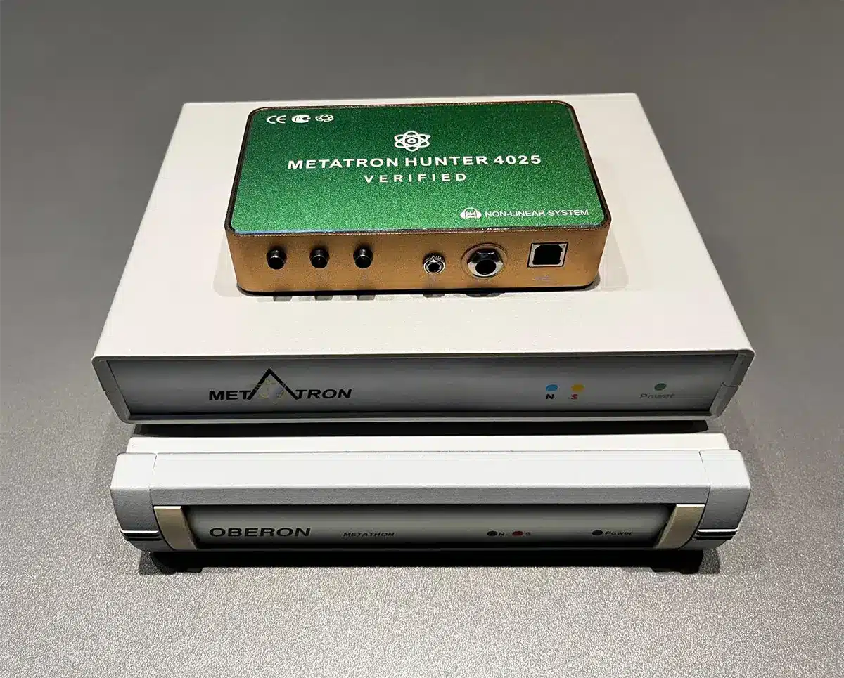 Metatron Hunter 4025 NLS Verified device placed above two original Oberon Metatron systems used for non-invasive bioresonance wellness assessments.